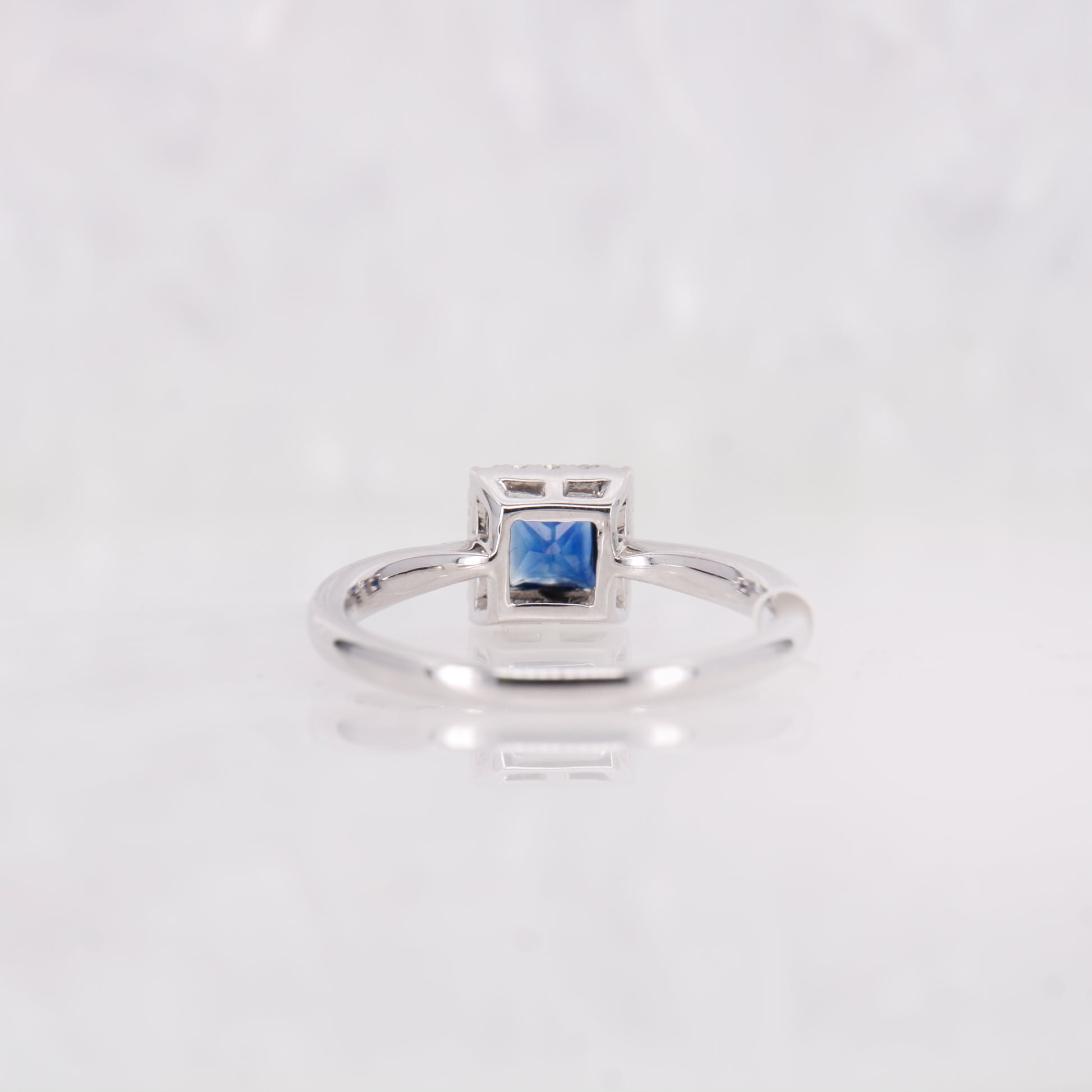 Sapphire and Diamond ring. Featuring a 0.45ct princess cut sapphire surrounded by a sparkling 0.10ct diamond halo.