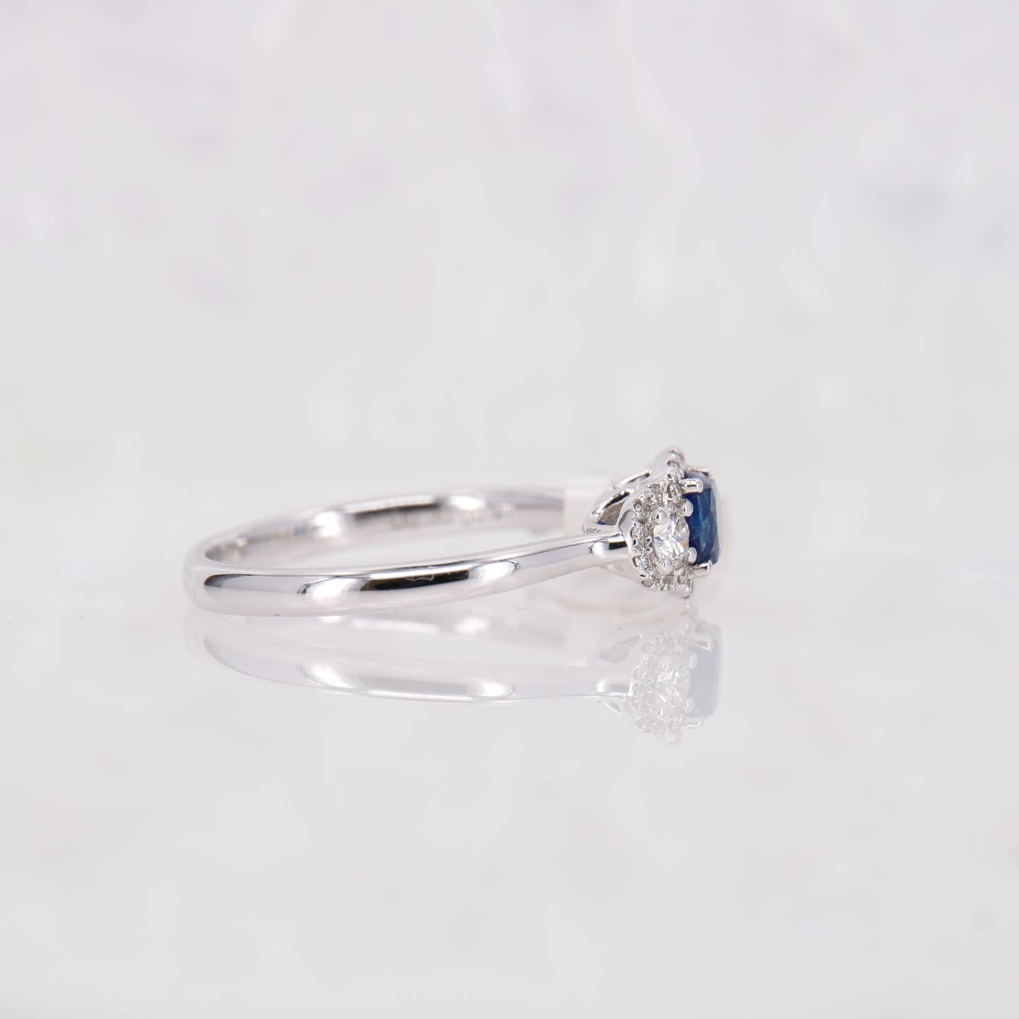 18CT White Gold Sapphire and Diamond three stone ring with a halo of diamonds surrounding. 