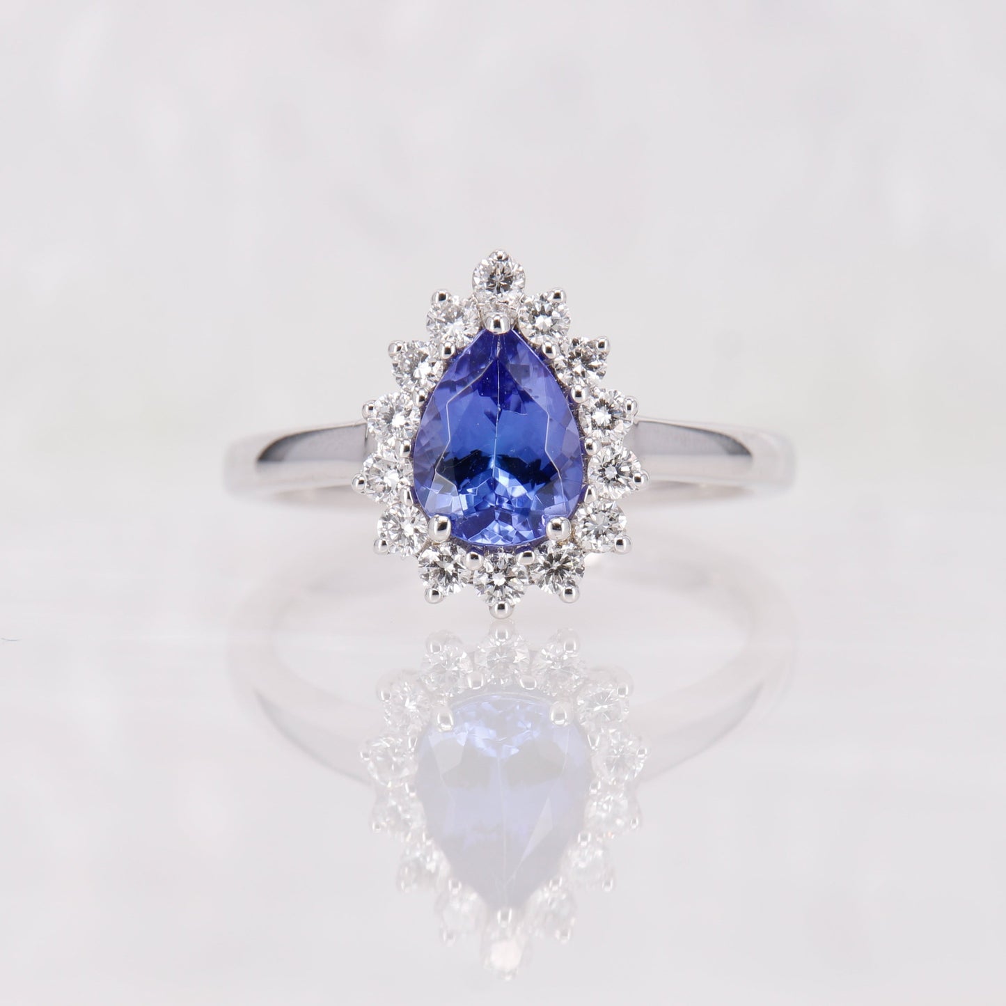 Tanzanite and Diamond Ring. Showcasing a captivating 1.32ct pear-cut deep blue tanzanite encircled by a halo of shimmering diamonds