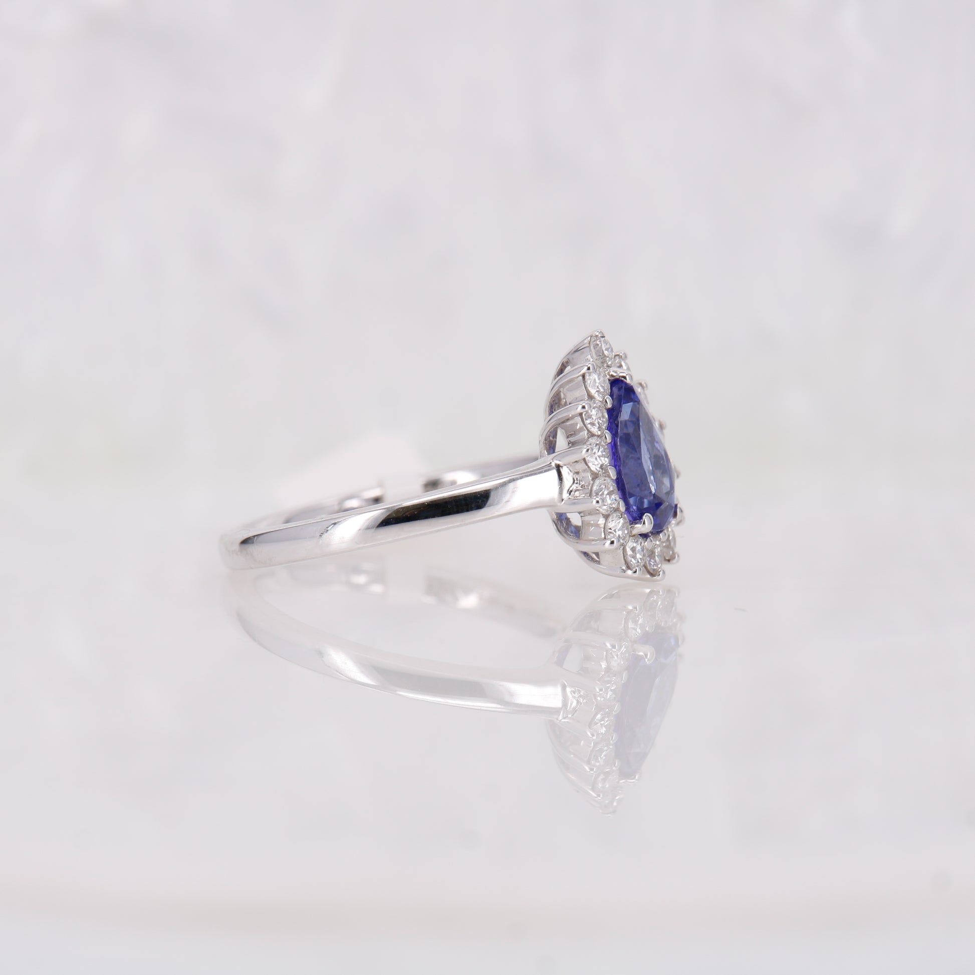 Tanzanite and Diamond Ring. Showcasing a captivating 1.32ct pear-cut deep blue tanzanite encircled by a halo of shimmering diamonds