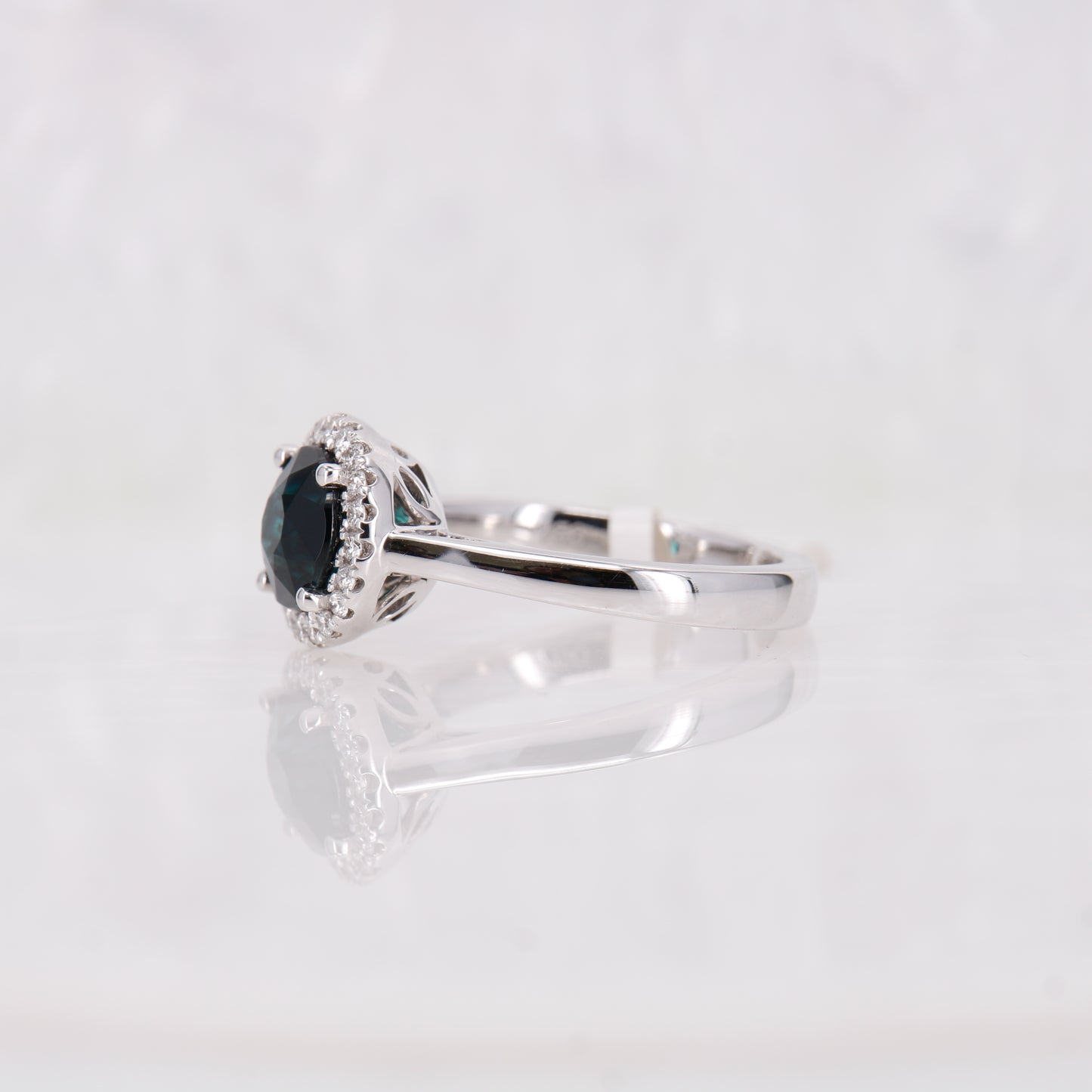Blue tourmaline and diamond halo ring set in 18ct white gold. 