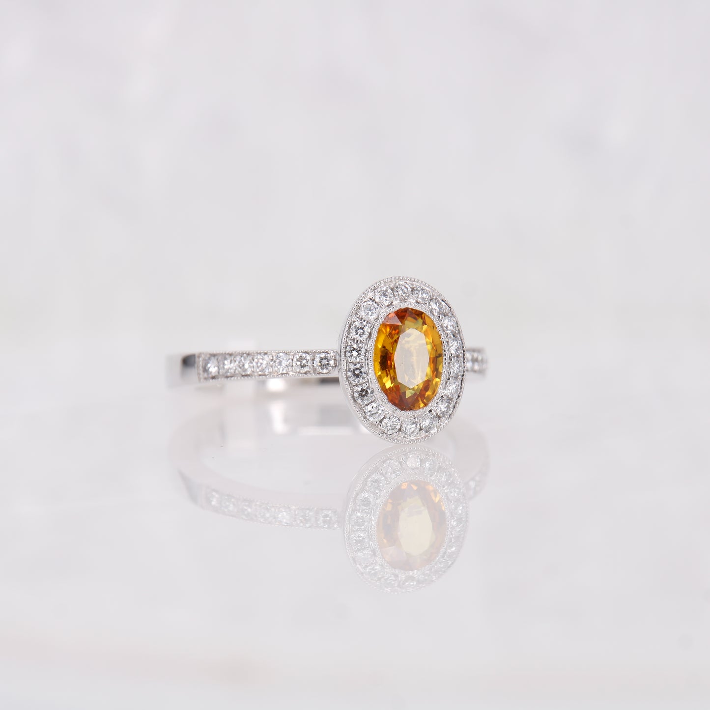 Yellow Sapphire oval engagement ring. Yellow orange sapphire surrounded by a halo of diamonds. 