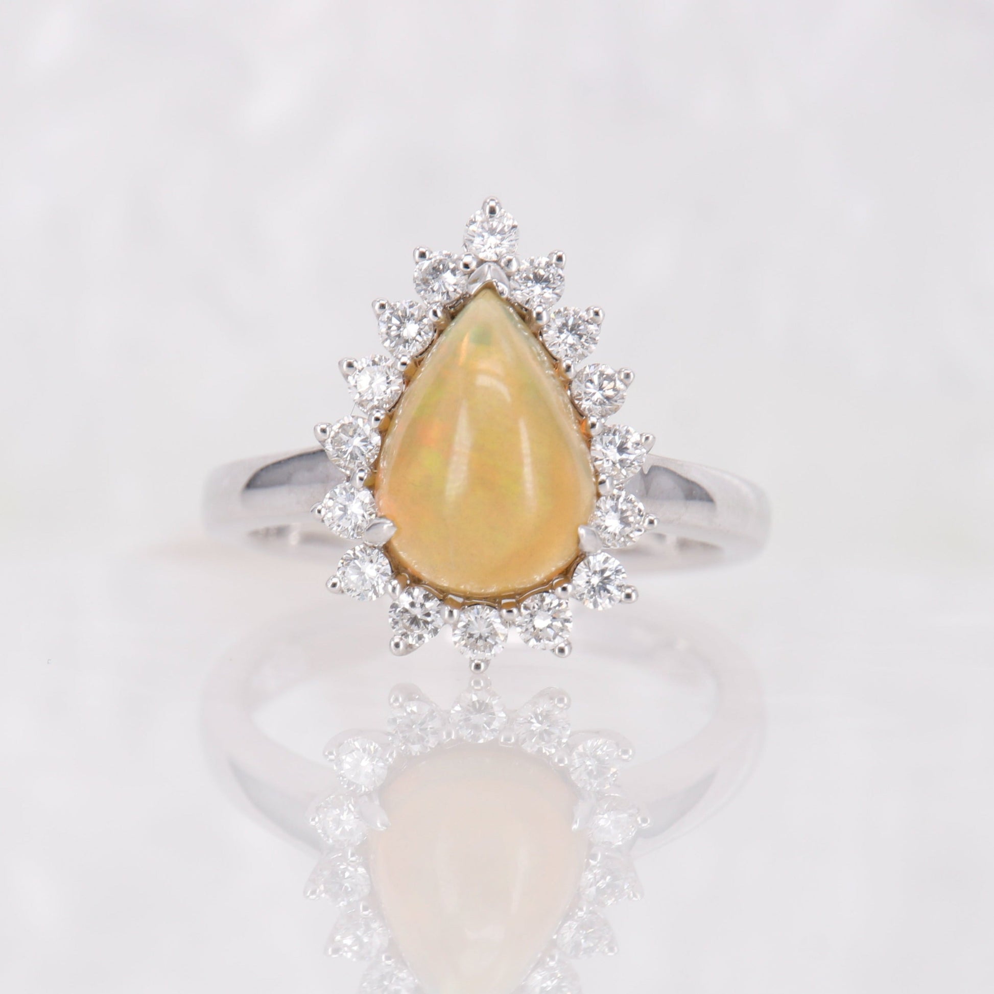Opal and Diamond Ring. Pear cut opal surrounded by a halo of round brilliant diamonds. 