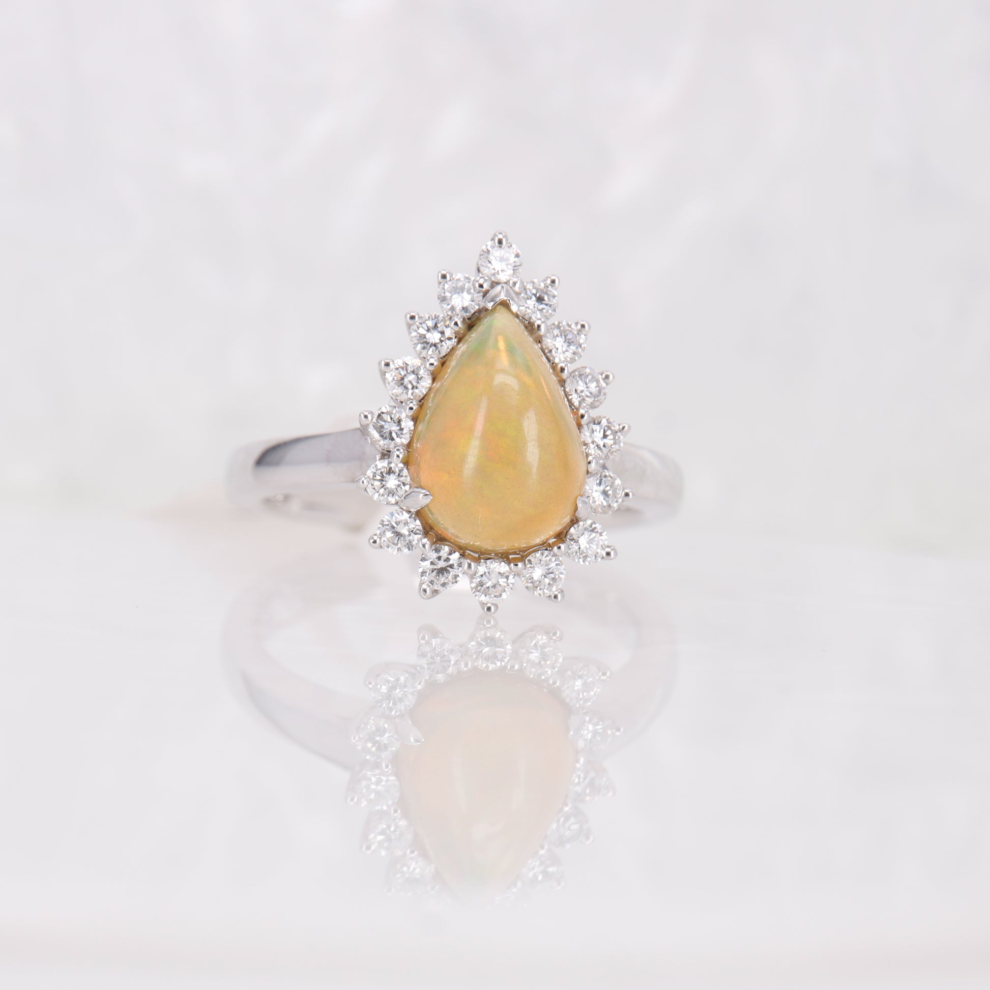 Opal and Diamond Ring. Pear cut opal surrounded by a halo of round brilliant diamonds.