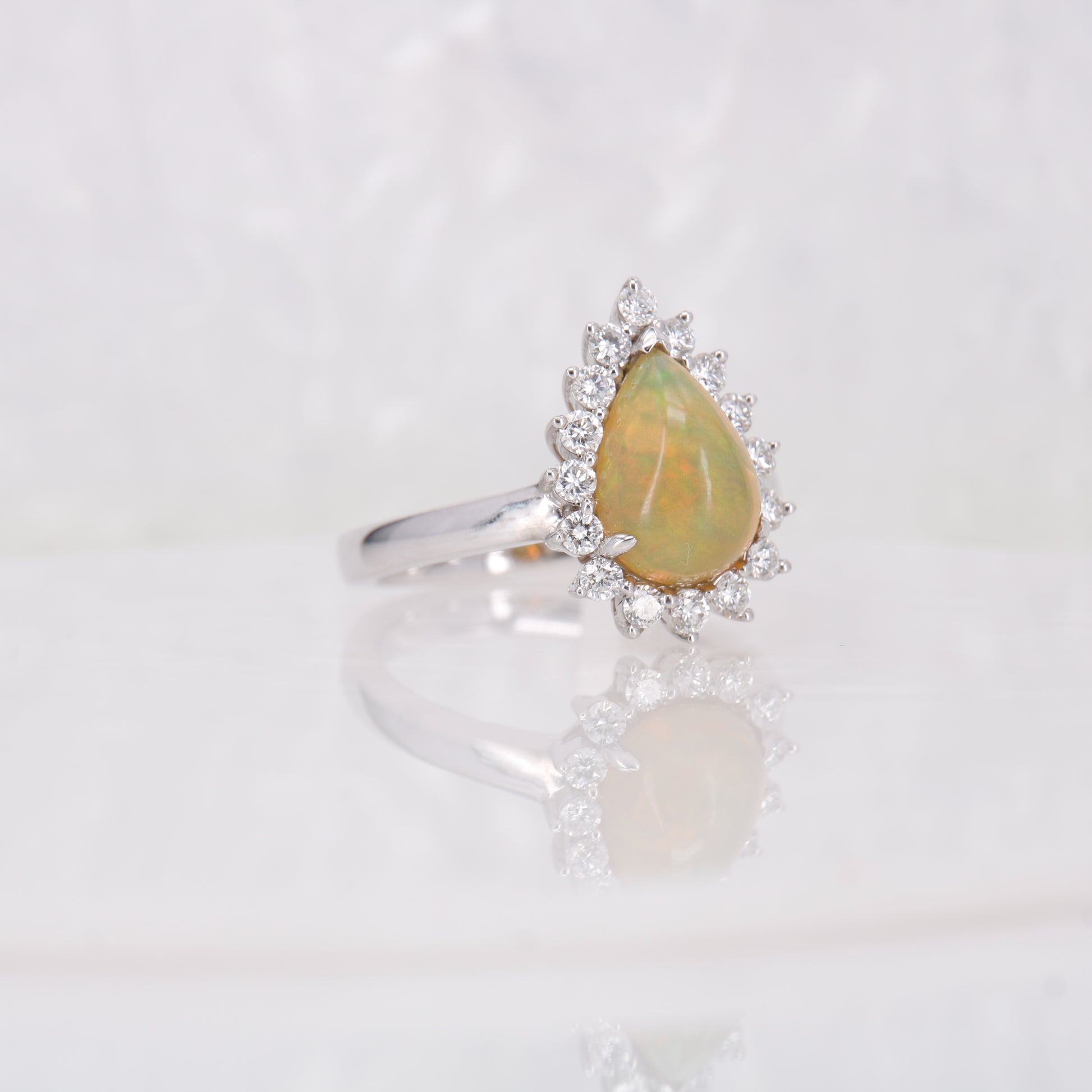 Opal and Diamond Ring. Pear cut opal surrounded by a halo of round brilliant diamonds.