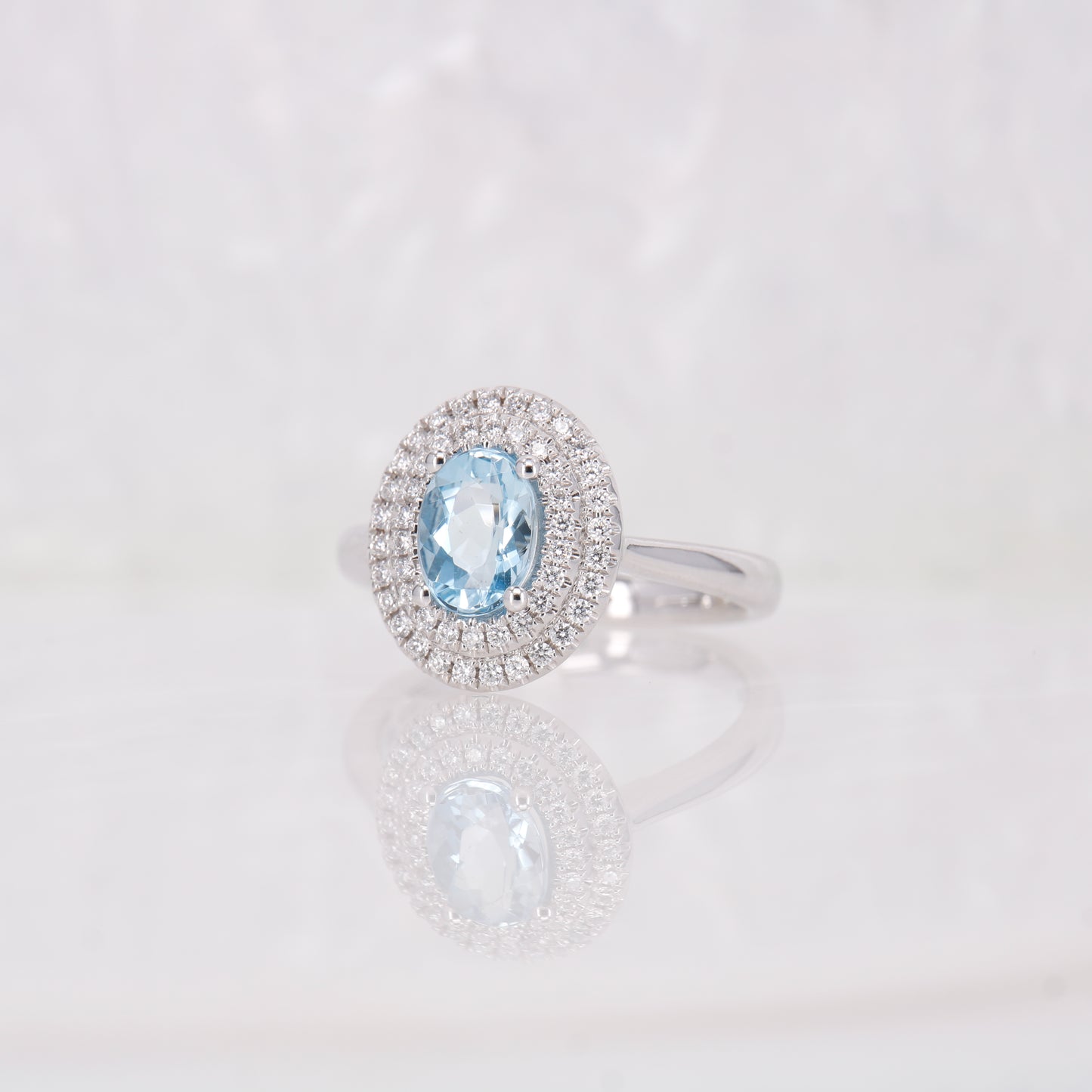 Oval Aquamarine and Diamond Ring featuring a double halo of diamonds. Set in 18ct White Gold. 