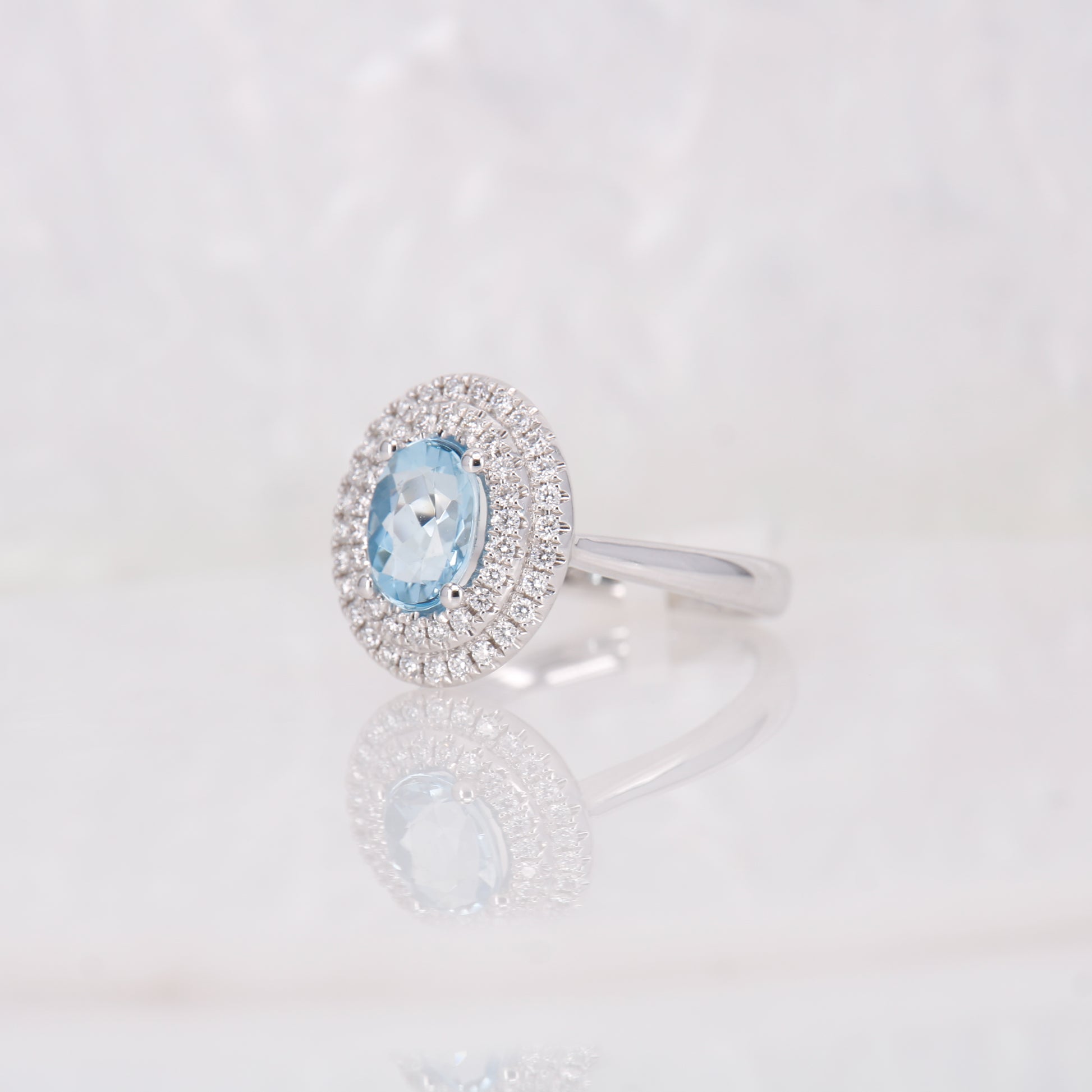Oval Aquamarine and Diamond Ring featuring a double halo of diamonds. Set in 18ct White Gold. 