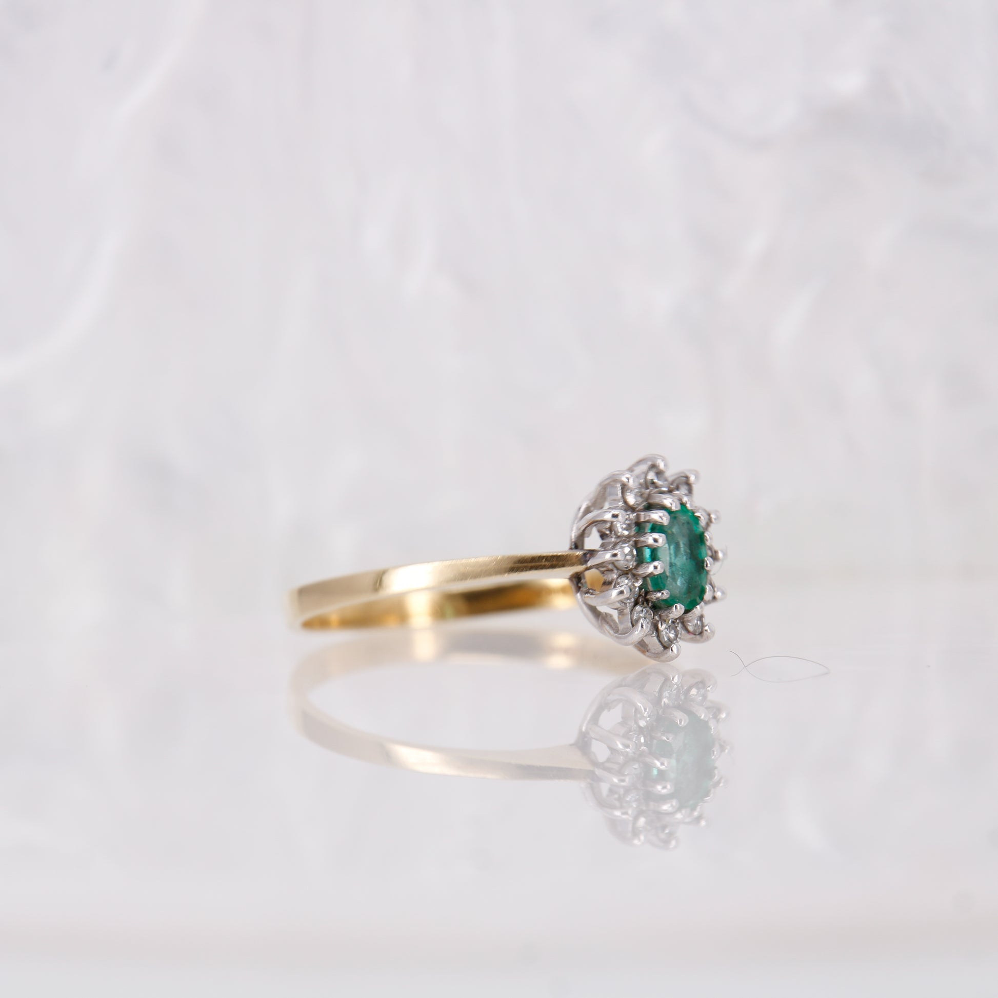 Secondhand Vintage 18ct Emerald and Diamond Ring. Oval cut emerald surrounded by a halo of diamonds.