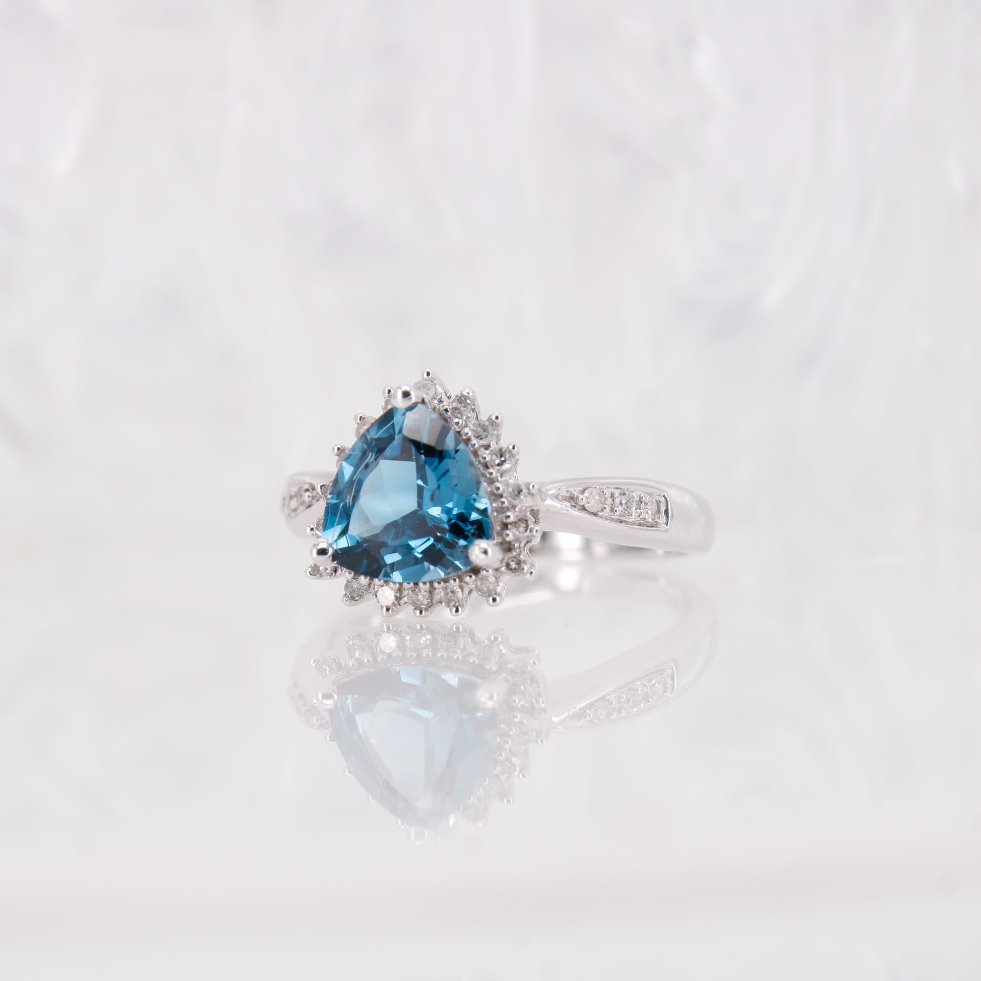 Blue Topaz and Diamond ring, Trilliant cut blue topaz with a halo of diamonds, white gold.