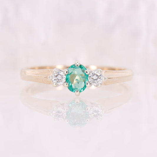 Pre owned oval cut emerald and diamond trilogy three stone ring yellow gold. 