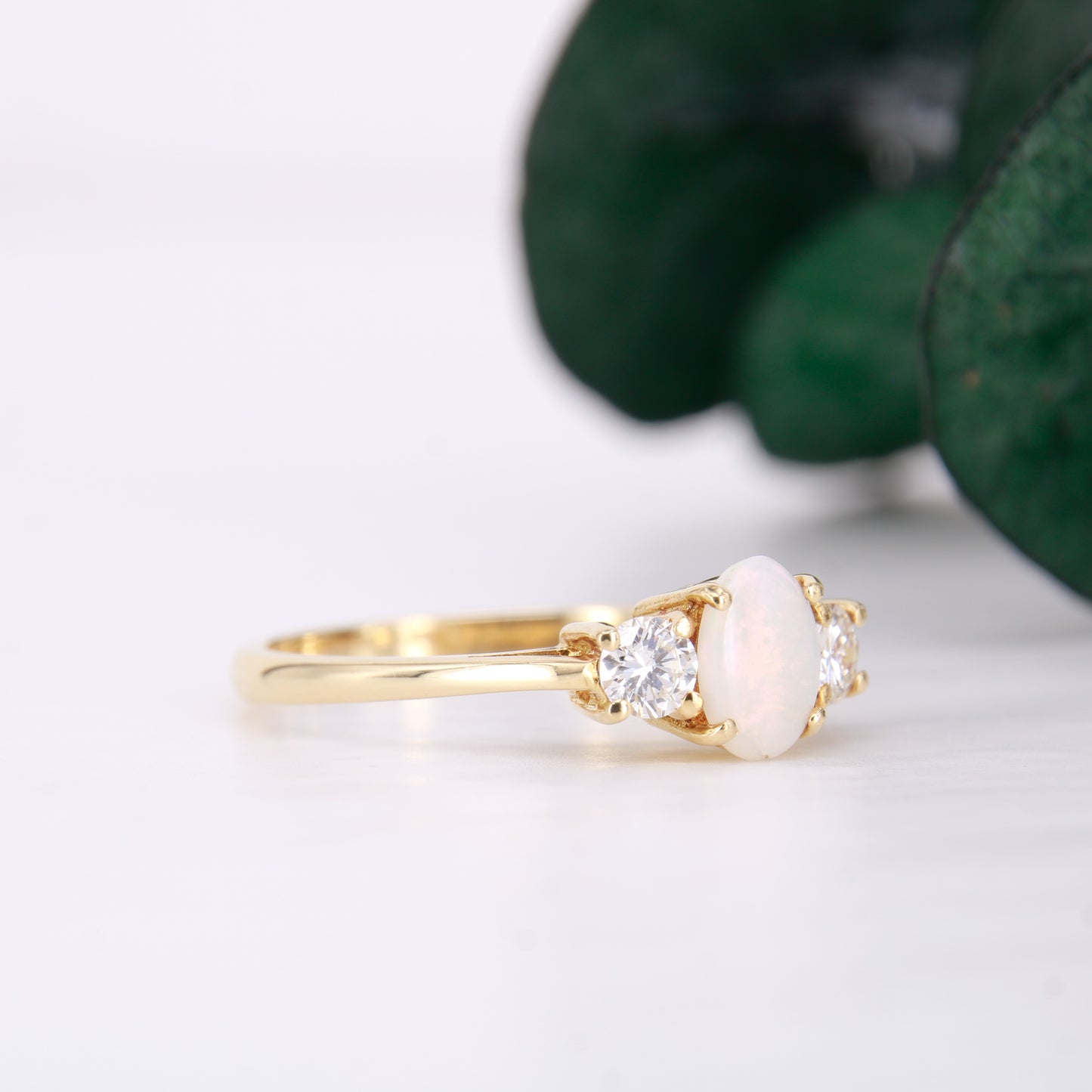 Pre-Owned Opal and Diamond three stone ring set in an exquisite 18ct yellow gold band . Her impressive 0.75ct opal offers beautiful flashes of colour and is partnered by round brilliant cut diamonds.