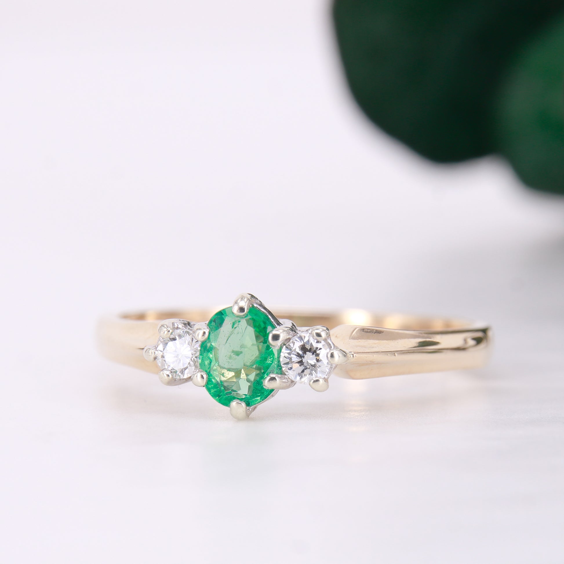 Pre owned oval cut emerald and diamond trilogy three stone ring yellow gold. 