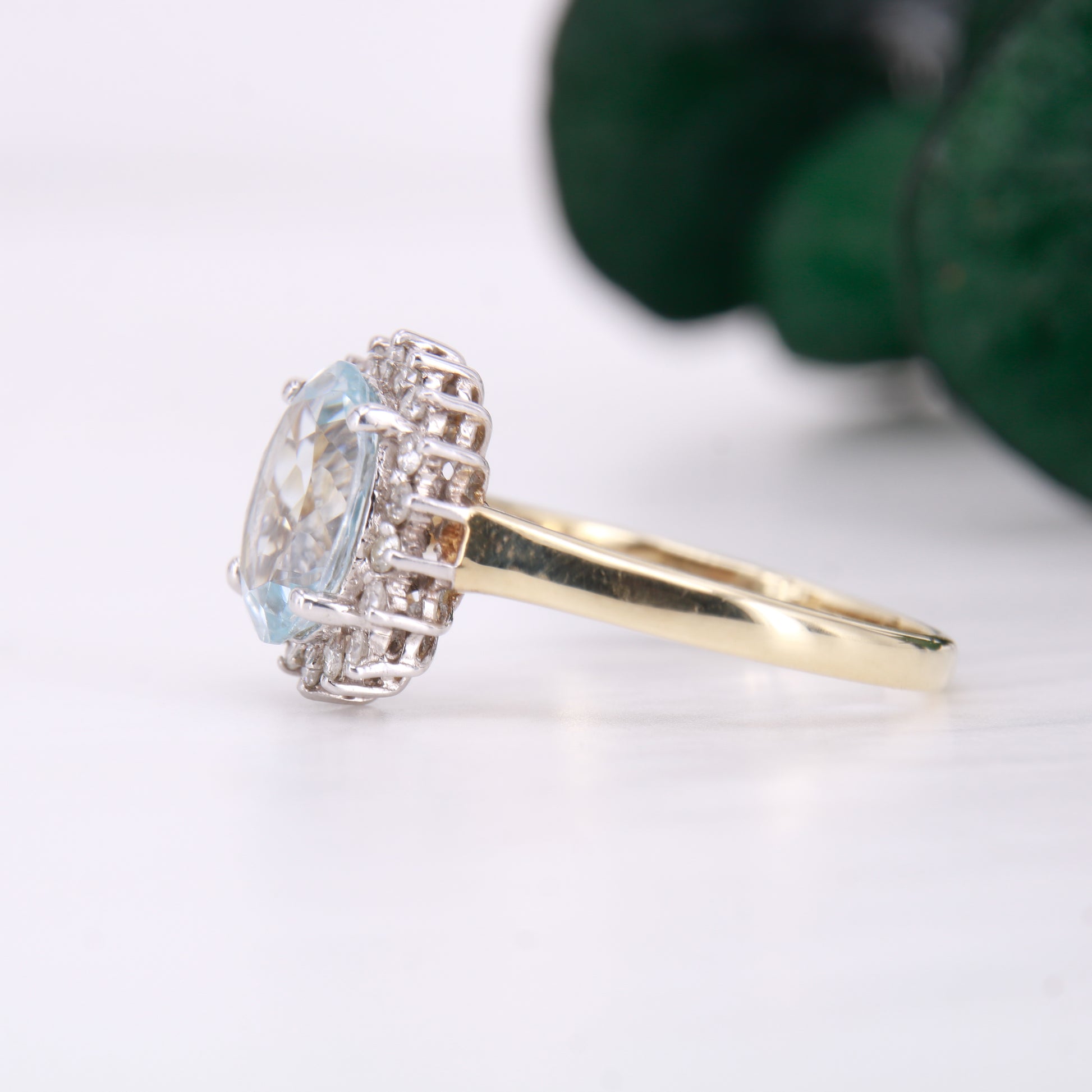 Preowned Aquamarine and Diamond Preowned Ring. Oval cut Aquamarine with a halo of diamonds set in 9ct yellow gold. 