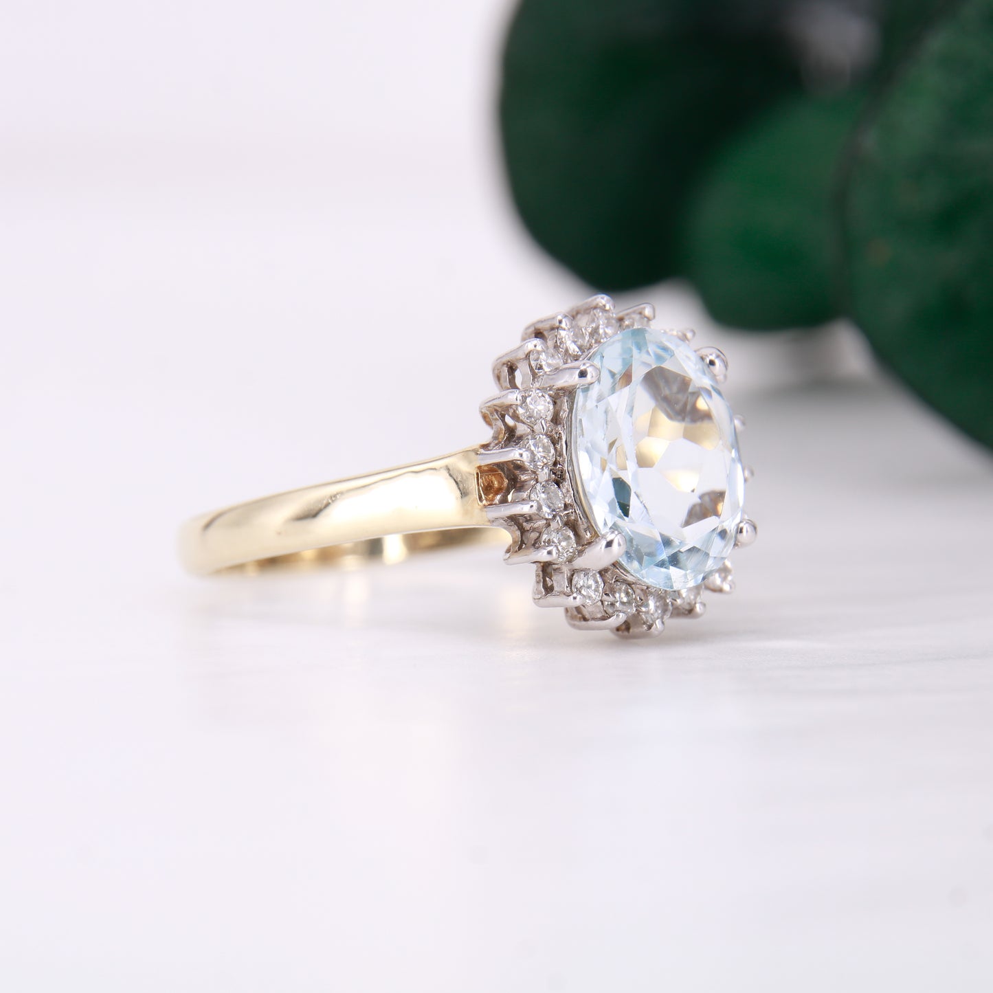 Preowned Aquamarine and Diamond Preowned Ring. Oval cut Aquamarine with a halo of diamonds set in 9ct yellow gold. 