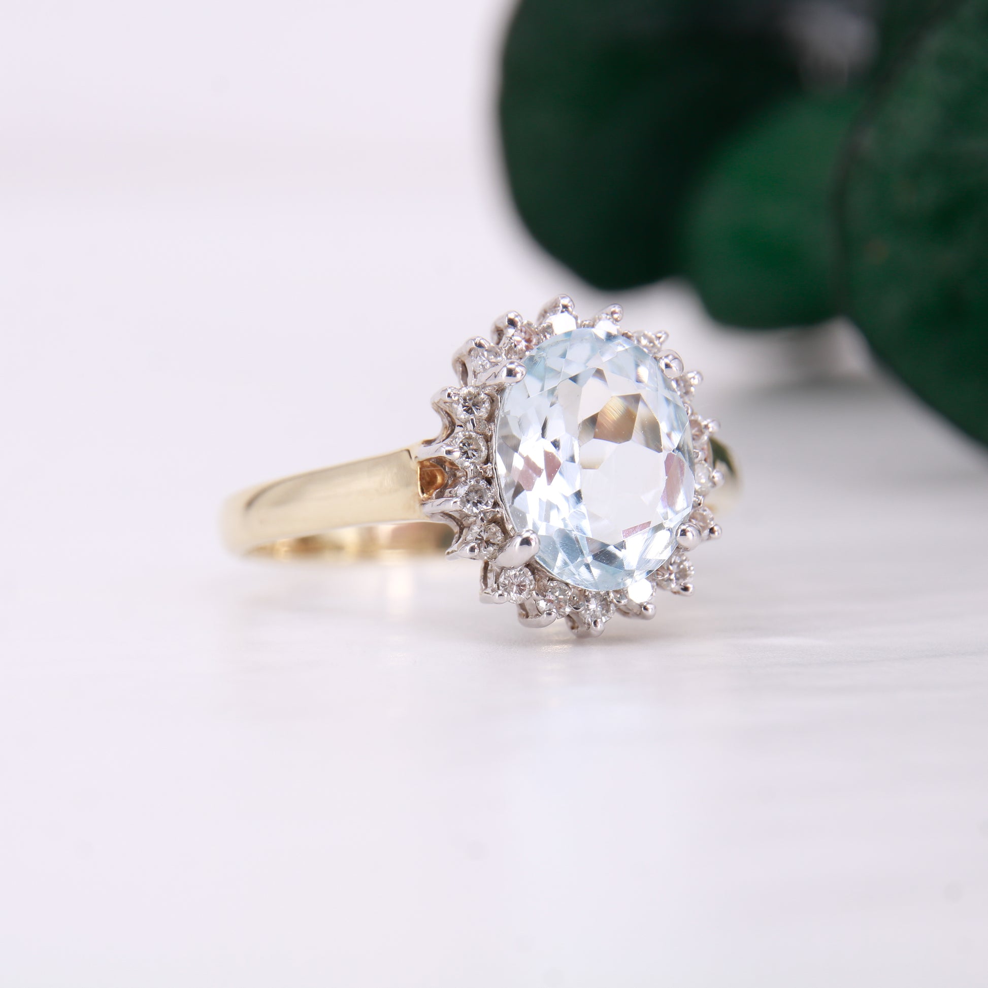 Preowned Aquamarine and Diamond Preowned Ring. Oval cut Aquamarine with a halo of diamonds set in 9ct yellow gold. 